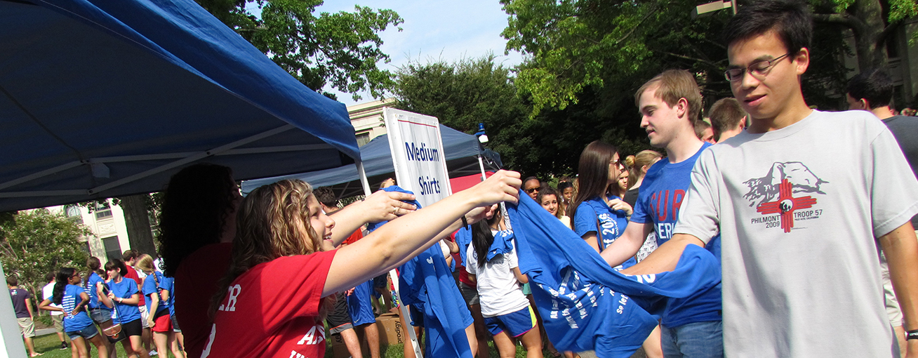 Volunteers hand out t-shirts at convocation.