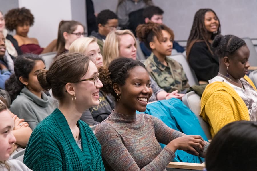 Students smile in the audience of the BOOMscat performance