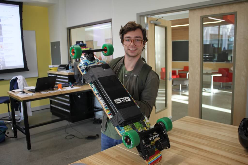 Tomy Muci holding electric skateboard