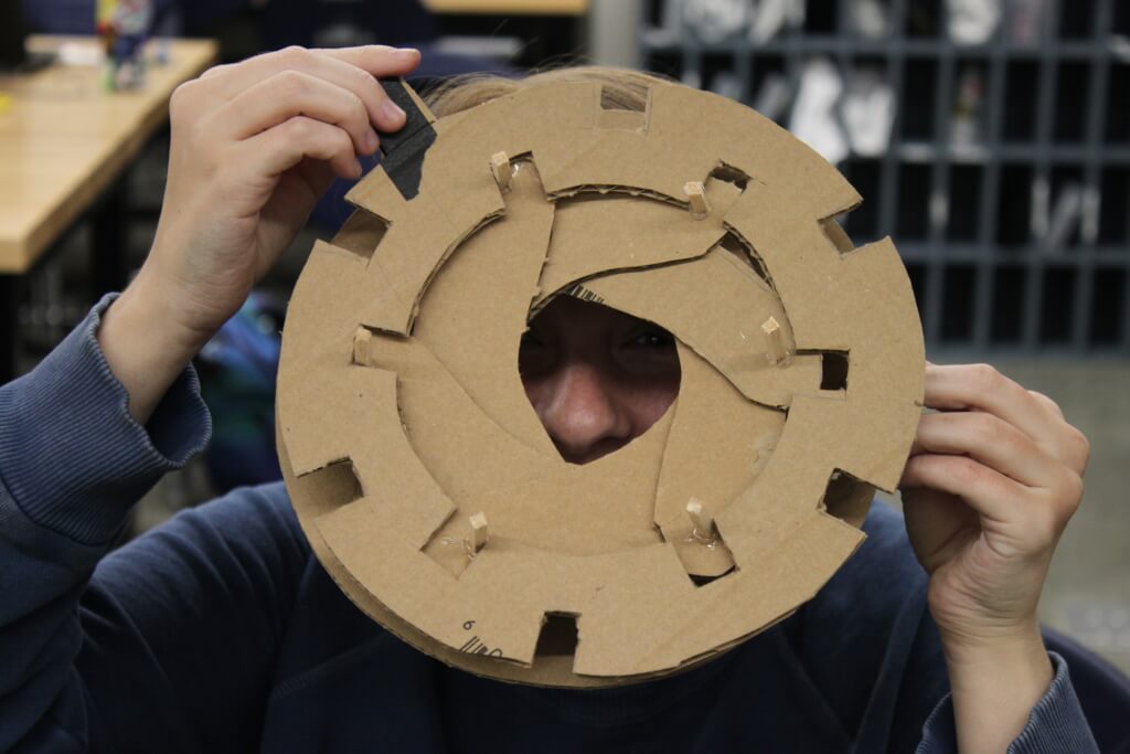 Bex Warner looking through their narrowed cardboard aperture