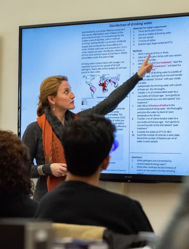 Classroom with faculty, students, and largescreen projection of drinking water disinfection material.