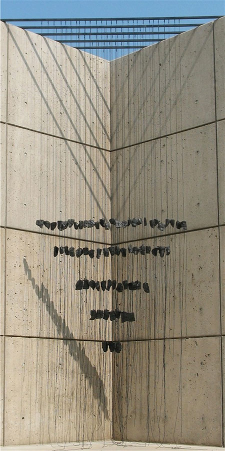 Barbara Liotta, Katzen Terrace,2007. Stones dangle on cords from metal bars above, forming a triangular pattern of lines.