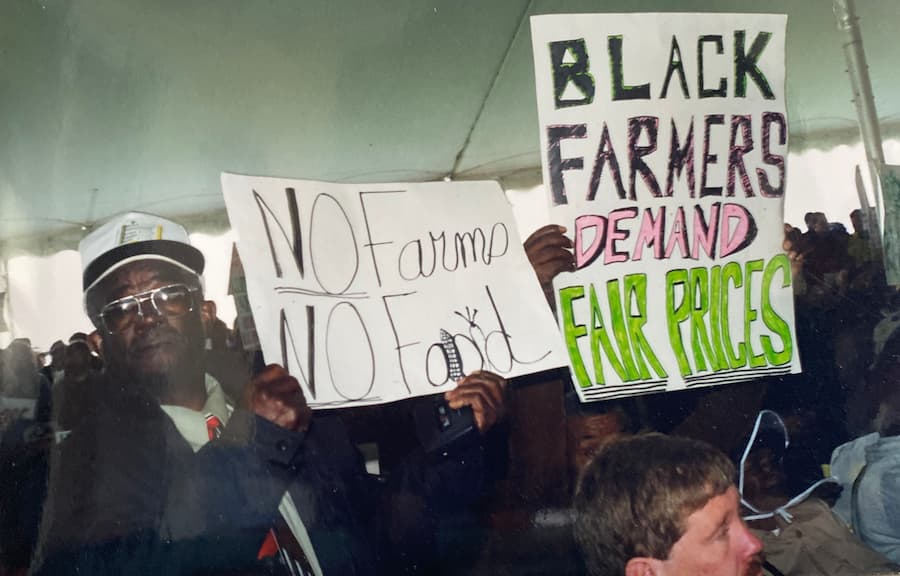 Vintage photo of farmers protesting, holding signs that read 