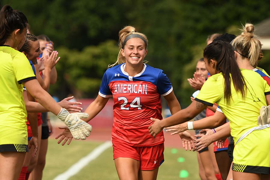 Jordan Mahony runs between rows of teammates, giving high fives