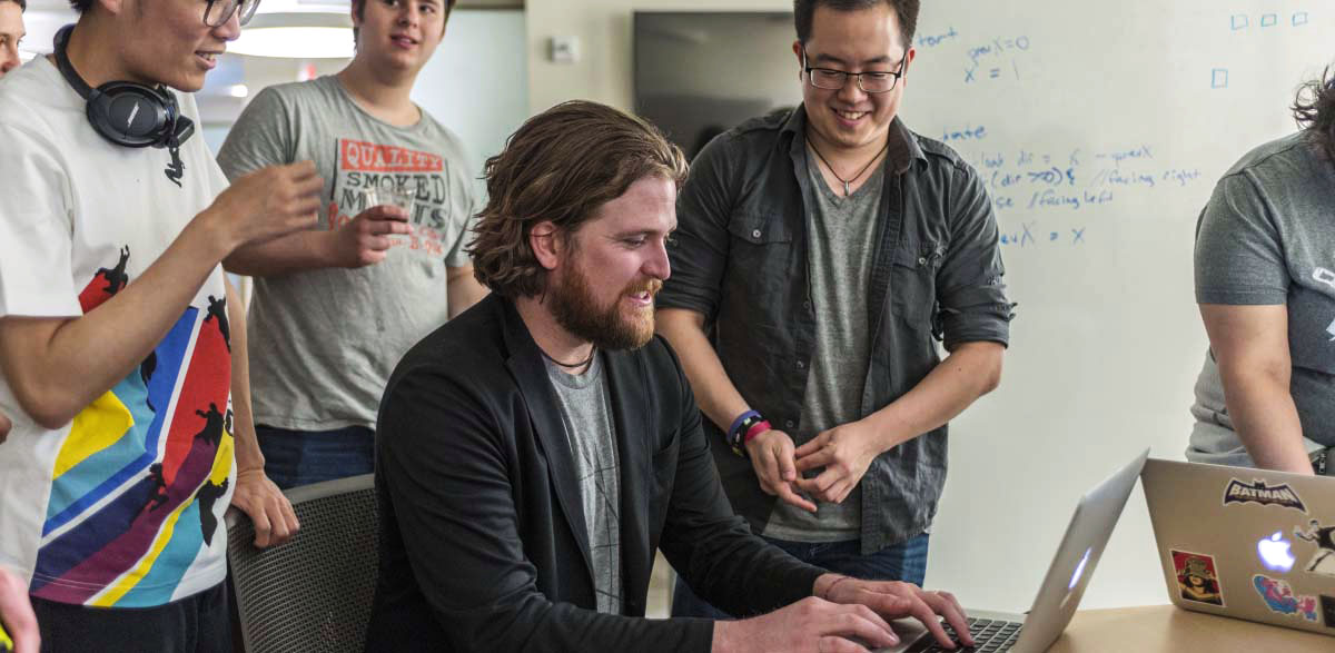 Mike Treanor demonstrates on computer for students in the Game Lab