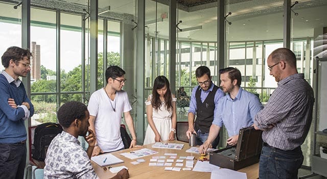 Diverse group of Game Lab students and faculty working on a game.