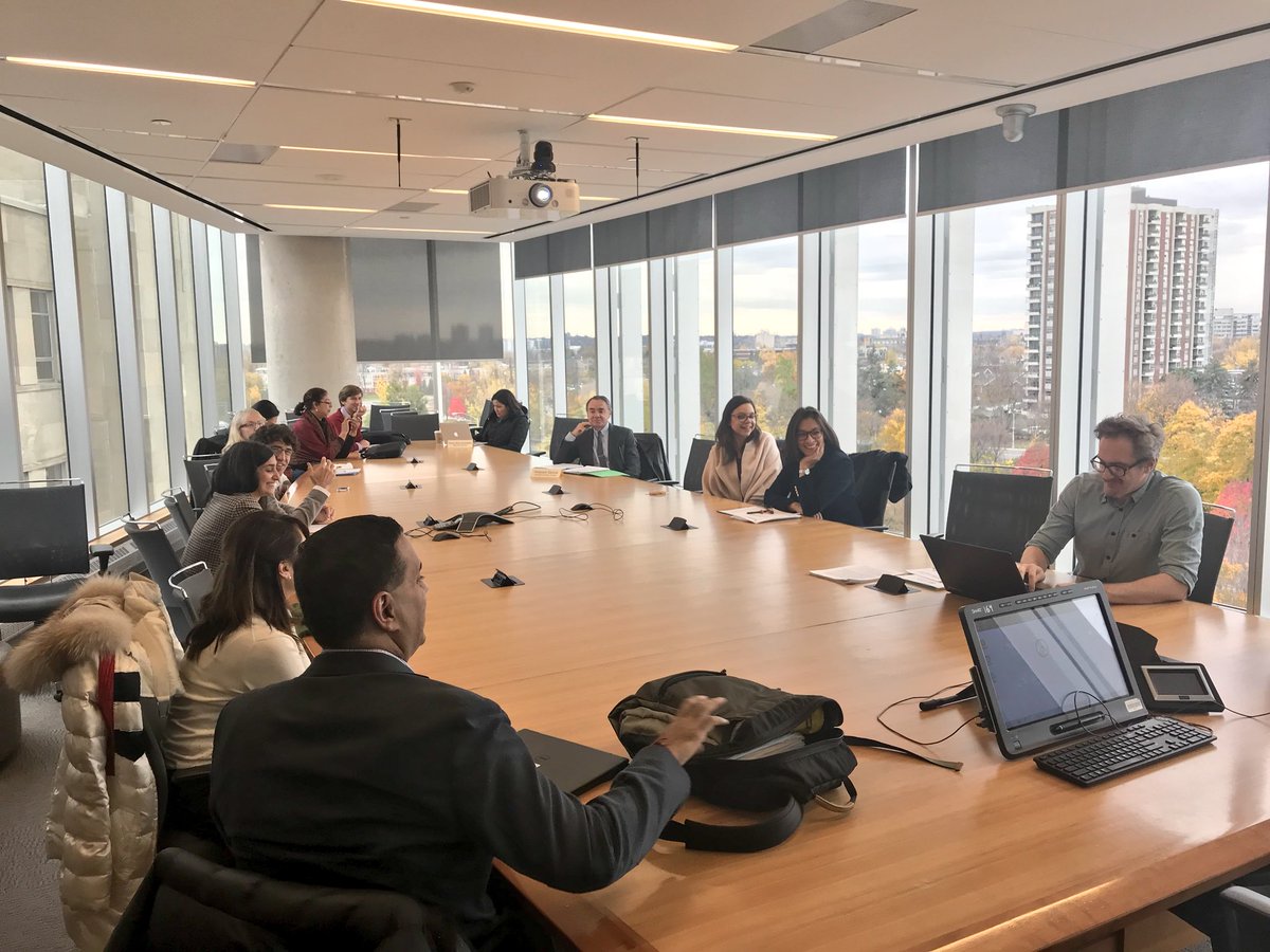 Group of men and women sit at a round table