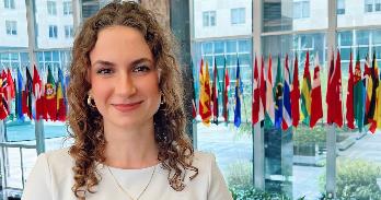 Francesca Gill in front of world flags.