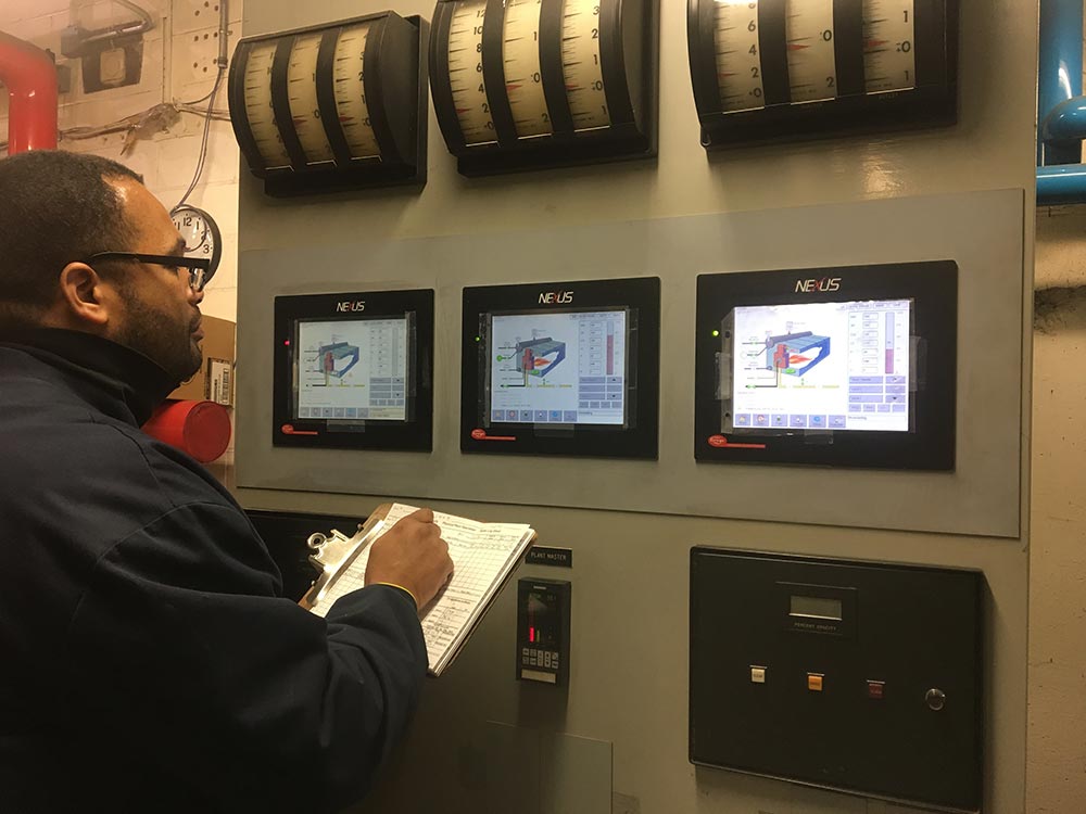 Worker inspecting machines in central plant