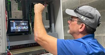 Dennis Smith, building automation technician, operates an automated logic control (ALC) panel.