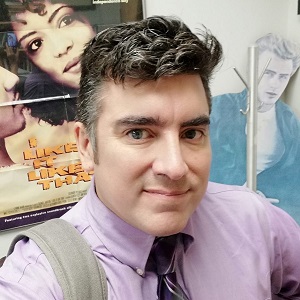 A profile photo of Jeff Middents in in his office wearing a light purple shirt. He is a light-skinned Latino man with short, dark hair.