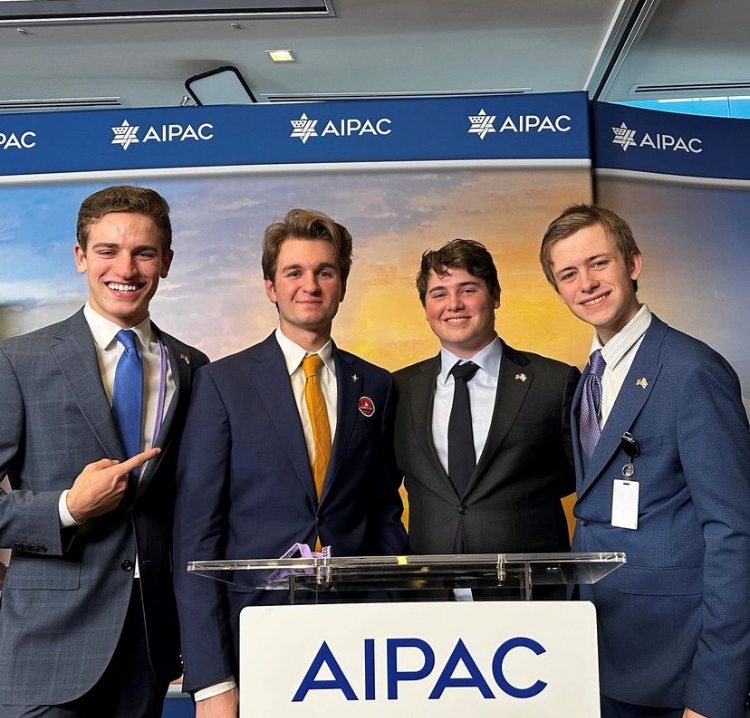 4 people standing in front of a podium, behind a sign