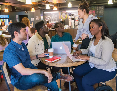 Five Frederick Douglass Distinguished Scholars sitting at a table in a coffee shop