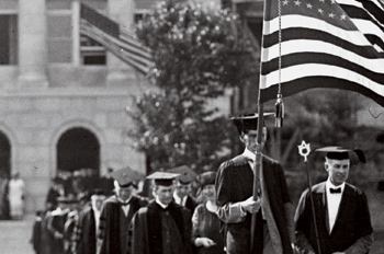 Old black and white of commencement procession on campus