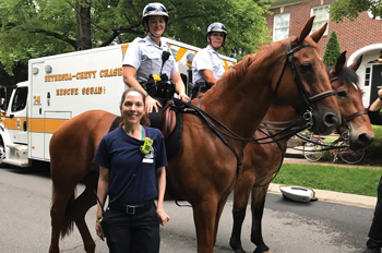 EMT Maryam Tabrizi in front of two police officers on horseback