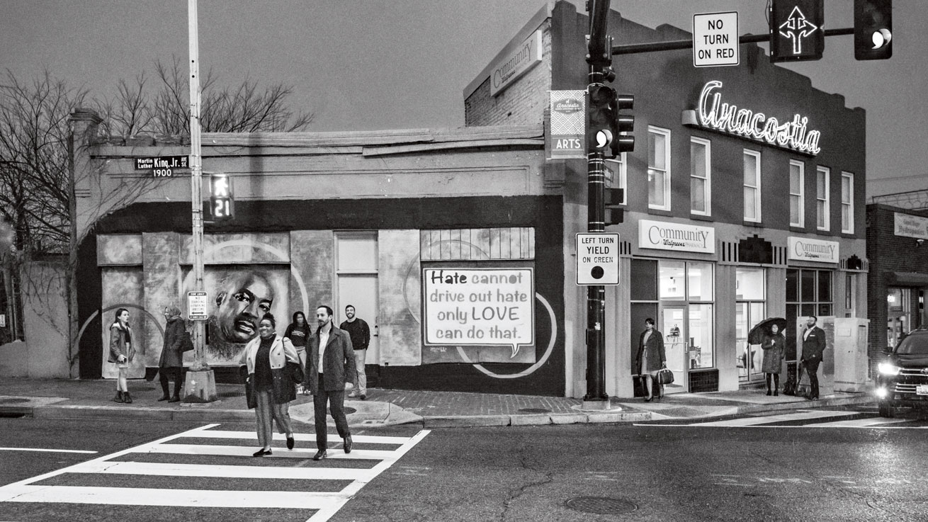 Nine people stand at a corner in Anacostia