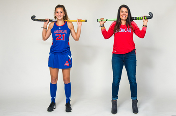 Aidan Rossman and Abbie Rossman hold field hockey sticks over their shoulders