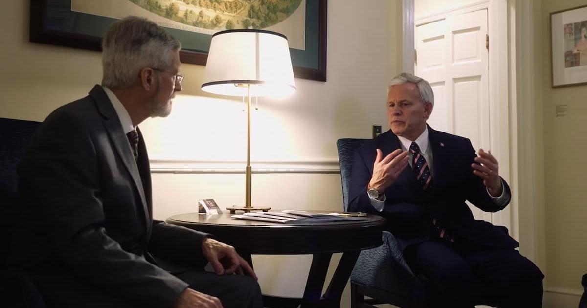 In this thumbnail from a video, H. Kent Baker speaks to AU President Jon Alger.