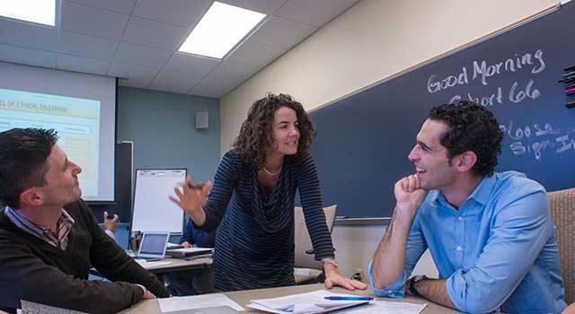 Graduate students confer during class