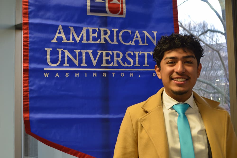 Edwin Santos standing in front of AU banner