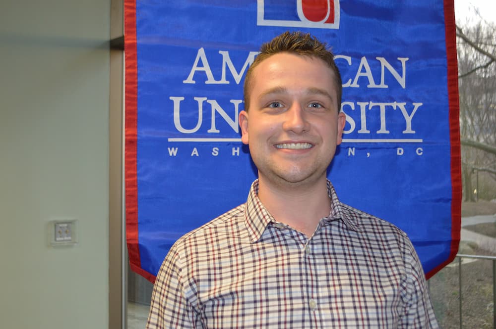 Jackson Beauregard standing in front of AU banner