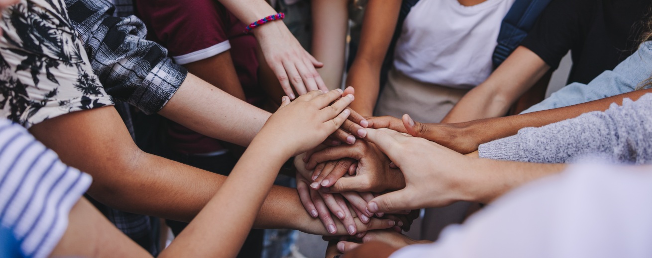 students putting hands together in huddle