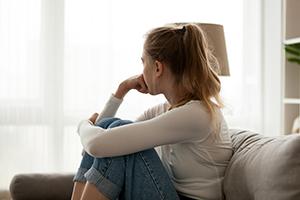 Anxious looking teen looking out the window