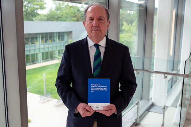 Juan-Mendezs holding his book by the window at AU